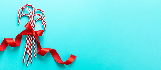 Christmas candy canes bunch on blue background. Merry Xmas greeting card template, space