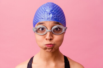 Swimmer with cap and goggles takes a deep breath before plunging into the water.