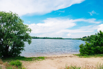 Beautiful sunny day, view of the river bank. Scenery. Blue sky with beautiful clouds. Warm, colorful look.	