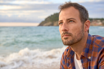 Thoughtful man spending sunset at beach
