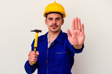 Young caucasian worker man holding a hammer isolated on white background standing with outstretched...