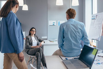 Obraz premium Group of employees are gathering informally in the office and chatting