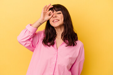 Young caucasian woman isolated on yellow background excited keeping ok gesture on eye.