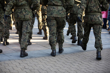 Rear view of marching soldiers in full uniform.