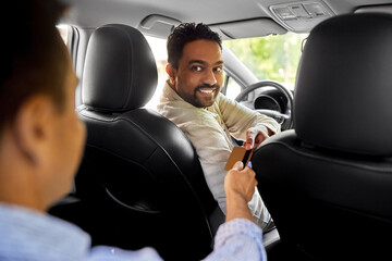 transportation and cash-free payment concept - indian male taxi car driver taking credit card from passenger