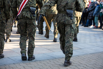 Soldiers march in parade step in full uniform. Rear view.