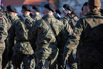 Young soldiers in black berets with guns and bayonets holstered.