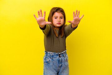 Little caucasian girl isolated on yellow background showing number ten with hands.