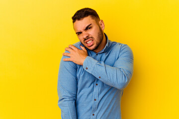 Young caucasian man isolated on yellow background having a shoulder pain.