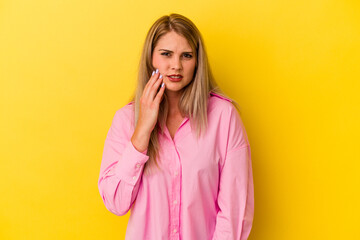 Young russian woman isolated on yellow background having a strong teeth pain, molar ache.