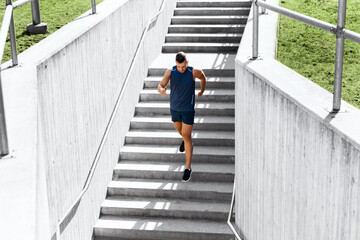 fitness, sport and healthy lifestyle concept - young man running downstairs