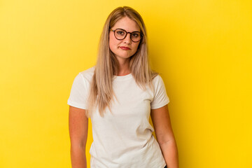 Young russian woman isolated on yellow background sad, serious face, feeling miserable and displeased.