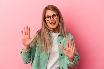 Young russian woman isolated on pink background rejecting someone showing a gesture of disgust.