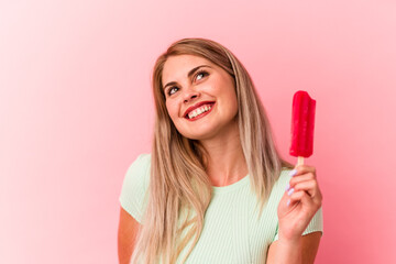 Young russian woman holding an ice cream isolated on pink background