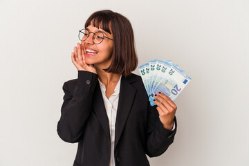 Young mixed race business woman holding a banknotes isolated on white background shouting and holding palm near opened mouth.