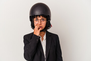 Young mixed race business woman wearing a motorbike helmet isolated biting fingernails, nervous and very anxious.