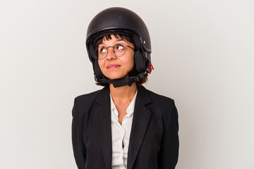 Young mixed race business woman wearing a motorbike helmet isolated dreaming of achieving goals and purposes