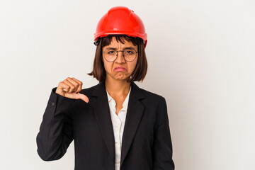 Young architect woman with red helmet isolated on white background showing a dislike gesture, thumbs down. Disagreement concept.