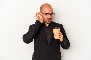 Young business bald man holding take away coffee isolated on white background  trying to listening a gossip.