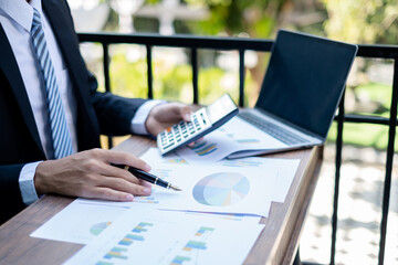 Young businessman financial market analyst sits at their desks and calculate financial graphs showing the results of their investments planning the process of successful business growth