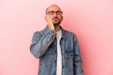 Young caucasian bald man isolated on pink background  tired and very sleepy keeping hand on head.