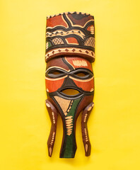 Wooden painted african mask isolated over yellow