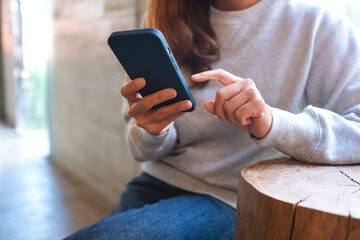 Closeup of a young woman holding and using mobile phone