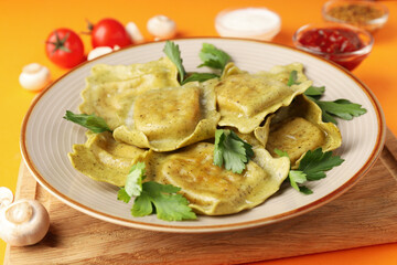 Delicious food concept with ravioli on orange background