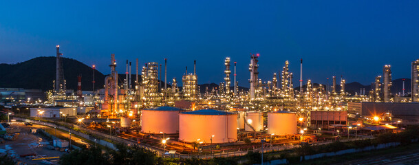 Aerial view. Oil refinery factory and oil storage tank at twilight and night. Petrochemical...