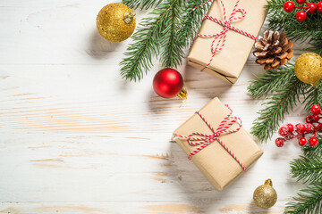 Christmas composition with fir tree, present box and decorations at white wooden table. Top view image with copy space.