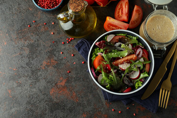 Concept of tasty food with vegetable salad with tahini sauce on dark textured background