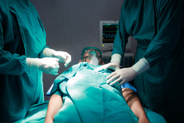 Two Asian surgeons working together on a surgery in operation room.