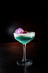 cocktail with gin, lime juice and soda on rustic wooden table on dark background