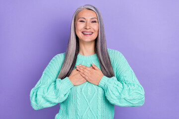 Photo of mature attractive woman arms on chest grateful glad promise isolated over violet color...