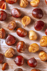 Baked chestnuts, overhead flat lay shot on a rustic wooden background
