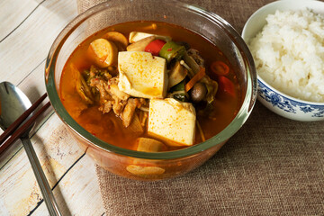 Korean soup, kimchi, tofu, pork with steamed rice