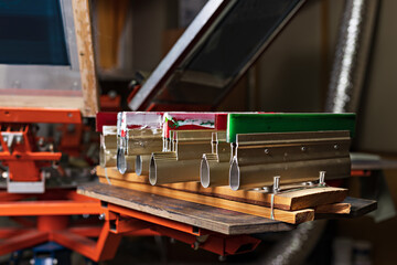 serigraphy production. squeegees on wooden shelve of the print screening apparatus.  printing...