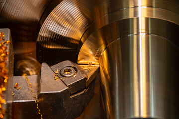 Close-up scene of lathe machine finishing cut the brass shaft parts by lathe tools.