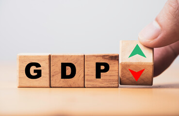 Hand flipping wooden cube block which print screen up and down symbol with GDP increase and decrease , GDP is Gross Domestic Product concept.