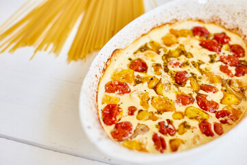 Trending viral recipe of baked tomatoes and feta with pasta, Fetapasta on a white wooden background