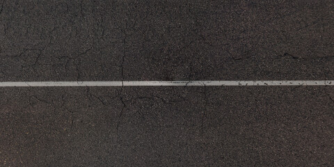 view from above on surface texture of old asphalt road with cracks