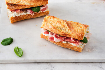 Ciabatta Sandwich with Jamon Serrano and spinach, on white background.