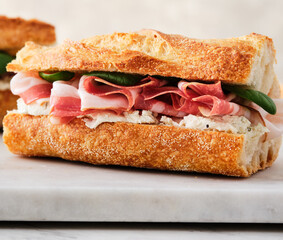 Ciabatta Sandwich with Jamon Serrano and spinach, on white background.