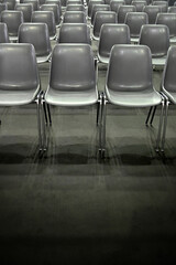 monochromatic image of gray empty audience seats arranged in rows selective focus