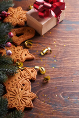 Christmas fir tree branches, Christmas balls, Christmas gingerbread, gift box, snowflakes and stars on old wooden background for xmas greetings. Selective focus, copy space. Christmas greeting card.