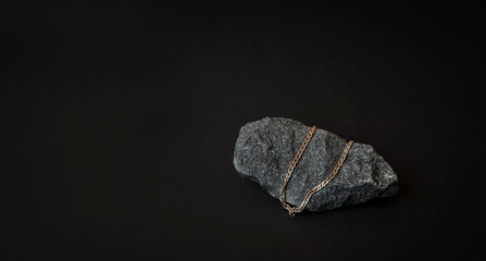 Black background. Dark gray stone. Non - ferrous metals. Minimal composition