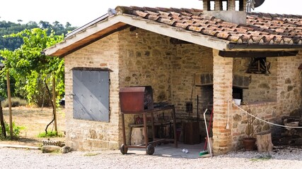 A stone oven with iron utensils for grilling meat with roof tiles and bricks in a farmhouse (Umbria, Italy, Europe) - 470665478