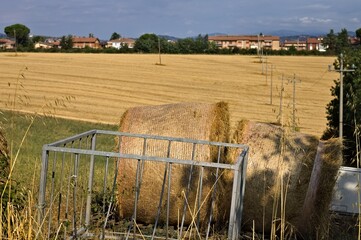 Hay bales behind a steel container in the Italian countryside (Umbria, Italy, Europe)