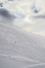 Ski slope. Covered with a layer of snow mountain slope on a background of cloudy sky.