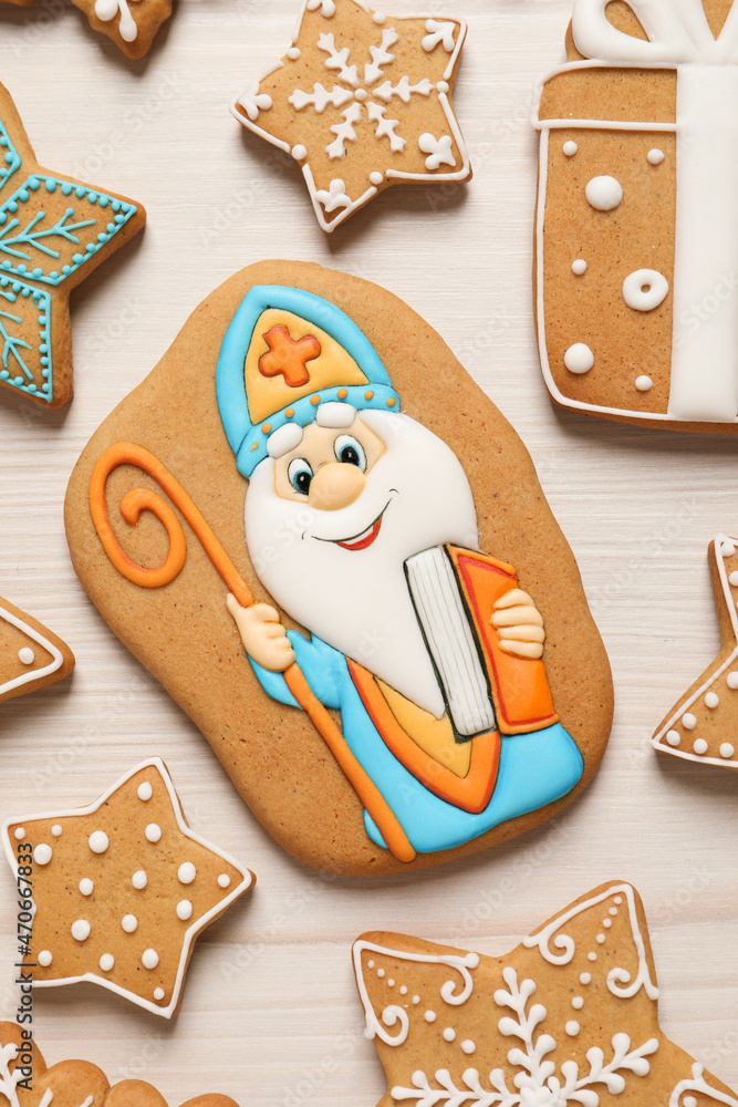 Wall mural Tasty gingerbread cookies on white wooden table, flat lay. St. Nicholas Day celebration